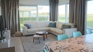 En moderne stue med en modulsofa, et sofabord og et spisebord.