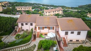 Un quartier résidentiel composé de maisons à étages, d’une terrasse avec mobilier d’extérieur et offrant une vue sur la mer.