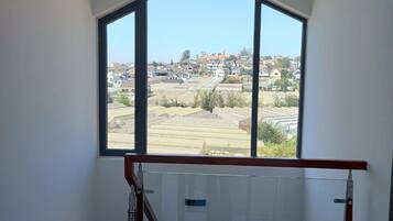 Una stanza con un'ampia finestra che si affaccia su una zona residenziale.