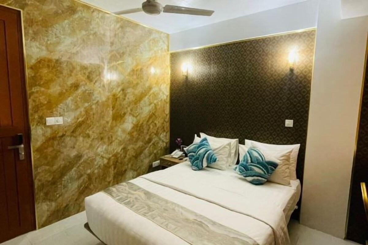 A hotel room with a bed, a nightstand, and a ceiling fan.