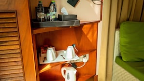 A wooden shelf with a kettle, cups, and a tissue box. - ZAN LODGE (Malé)