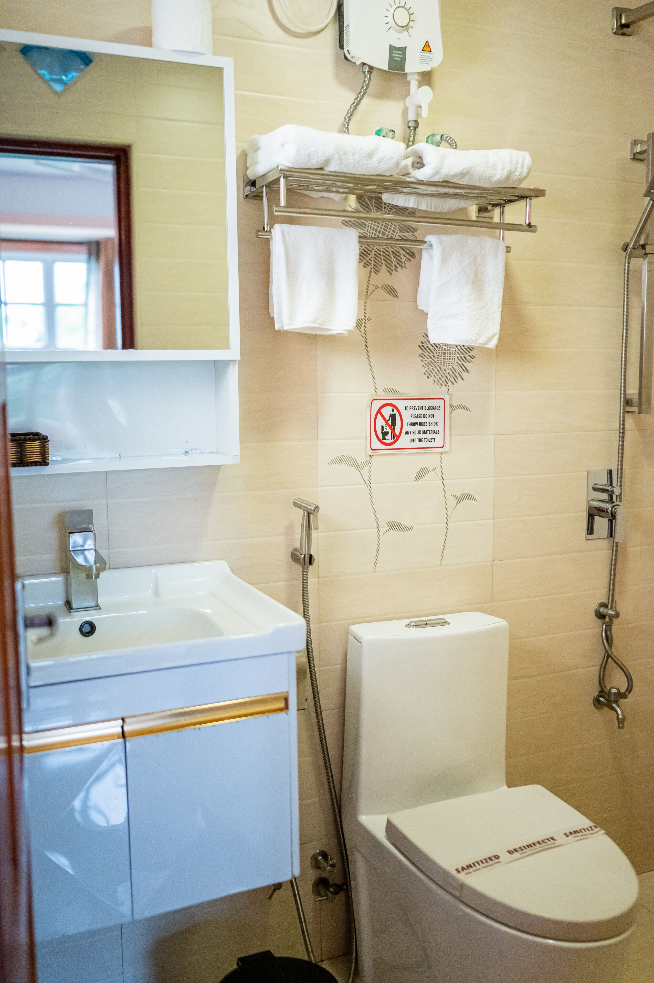 Een badkamer met een wastafel, toilet en handdoekhouder.