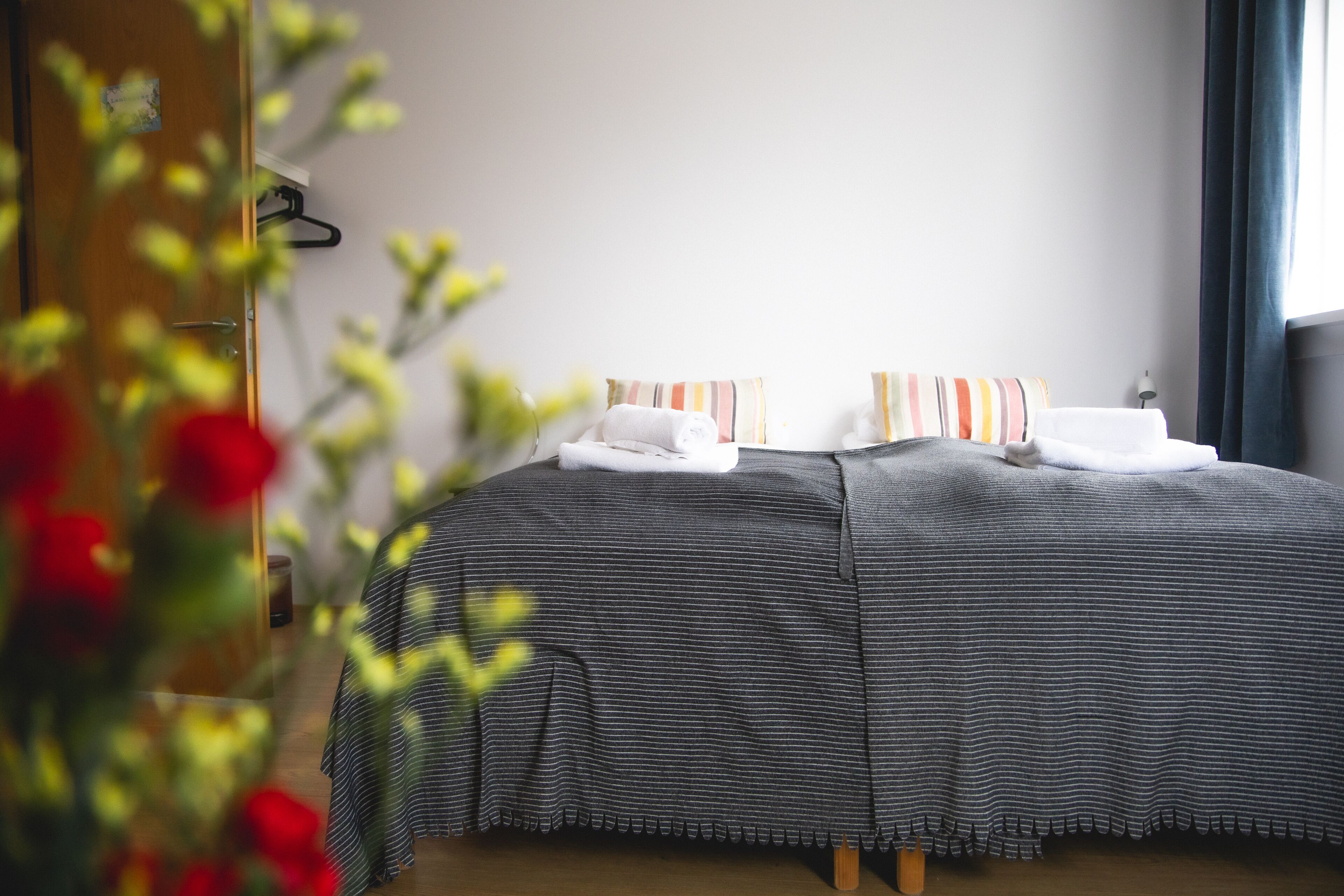 A hotel room with a bed, pillows, and a nightstand.