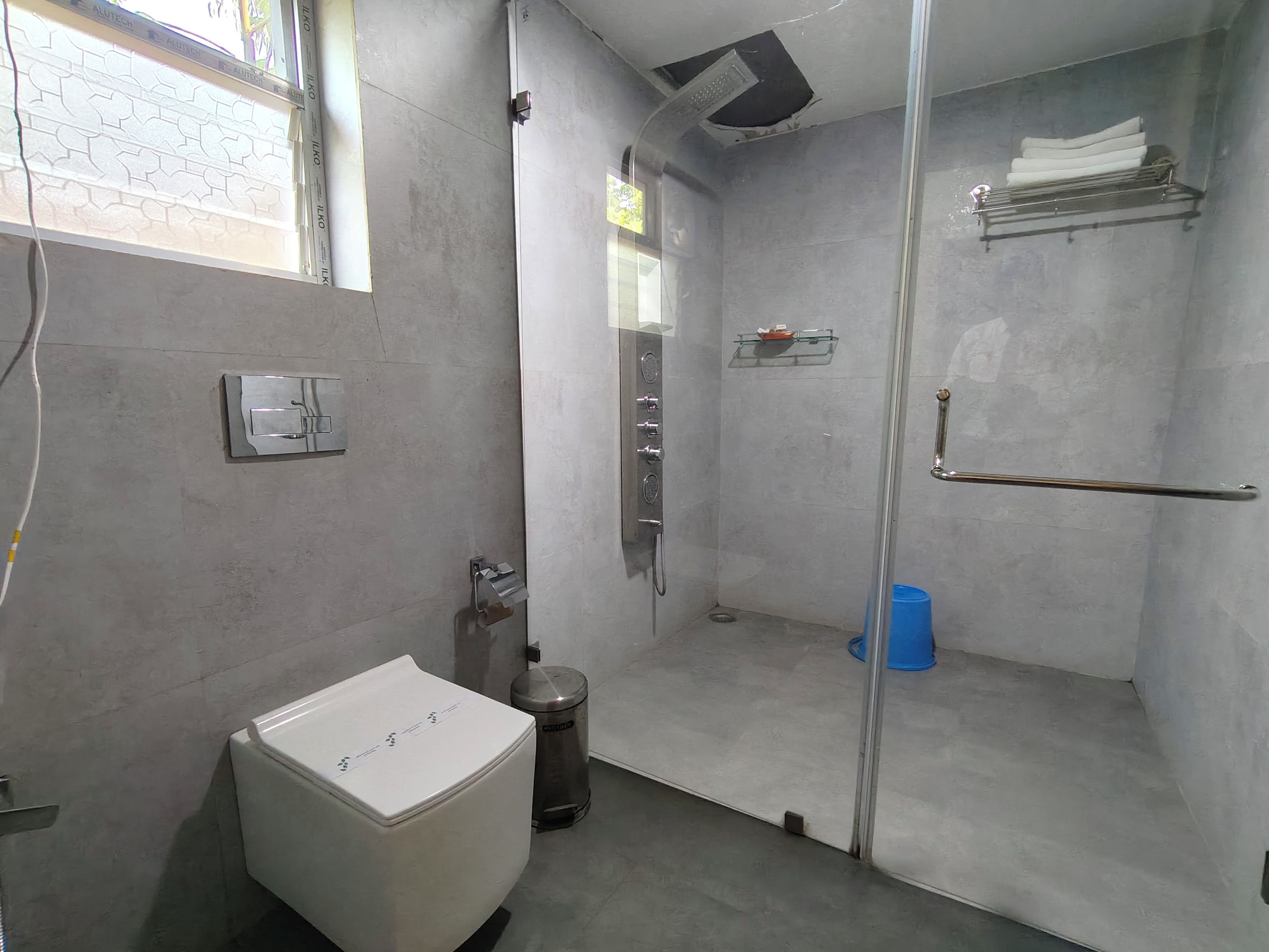 A bathroom with a toilet, a shower stall, and a sink.