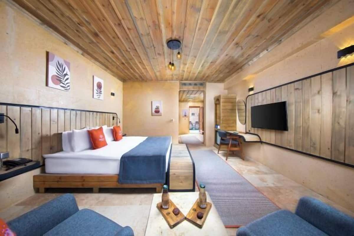 A room with a bed, a TV, and a massage table.