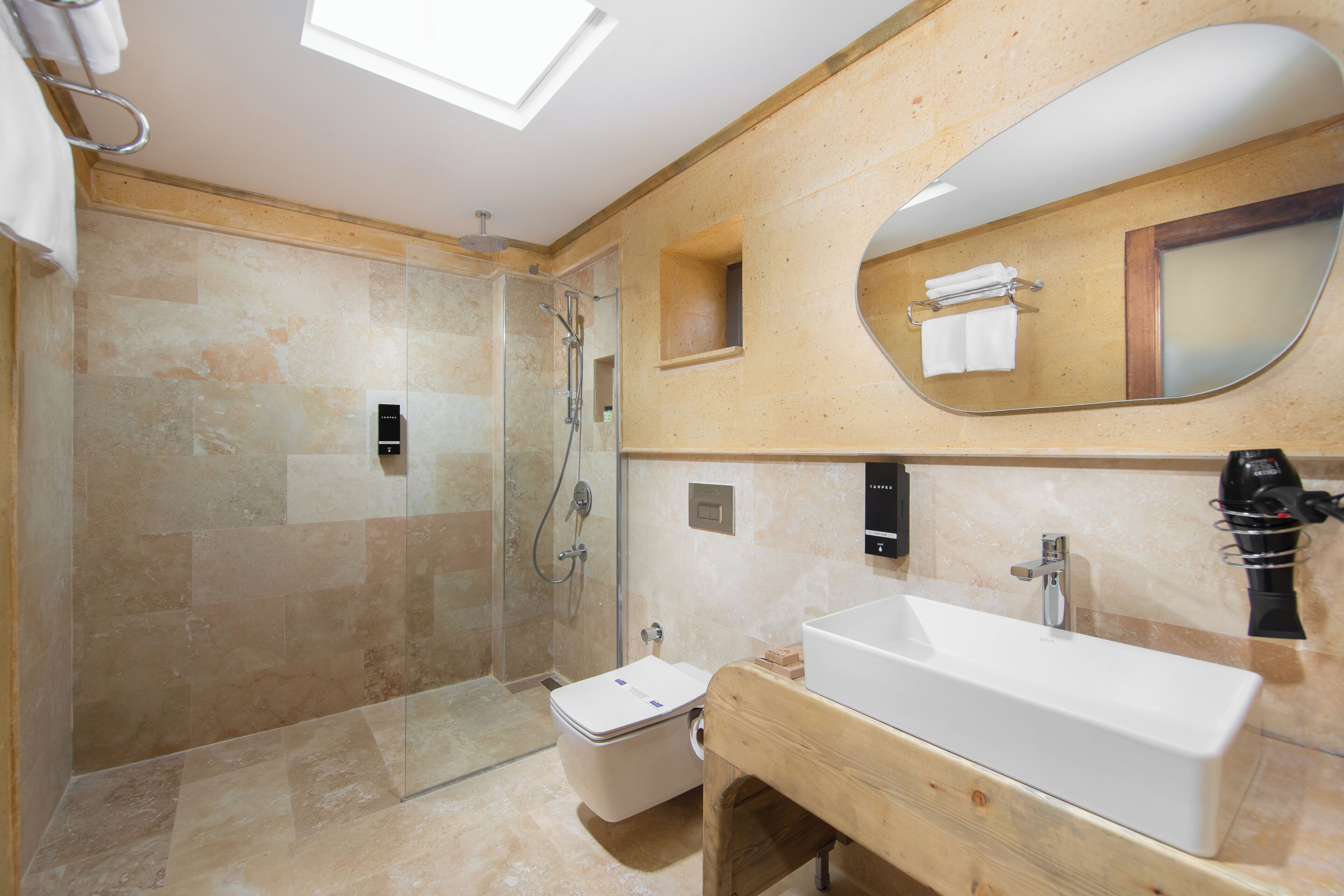 A modern bathroom with a glass-enclosed shower, a wooden vanity, and a large mirror.