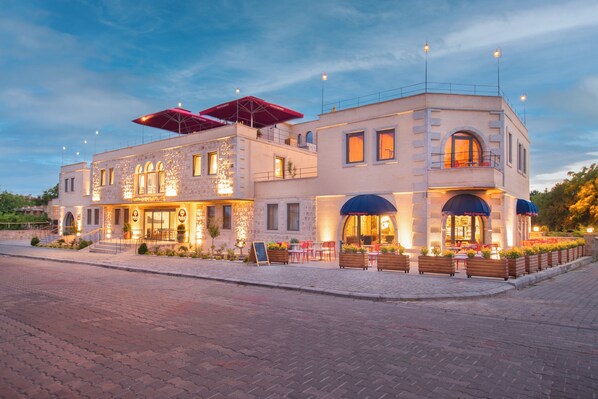 A two-story building with a stone facade, outdoor seating area, and a covered patio. - Breeze Of Cappadocia (Nevsehir)