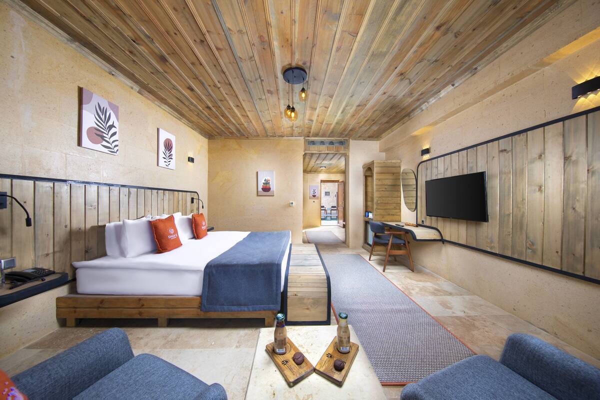 A cozy room with a bed, seating area, and a TV.