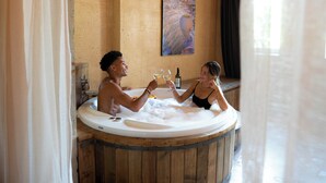 A couple in a wooden hot tub with a painting on the wall and a bottle of wine. - Breeze Of Cappadocia (Nevsehir)