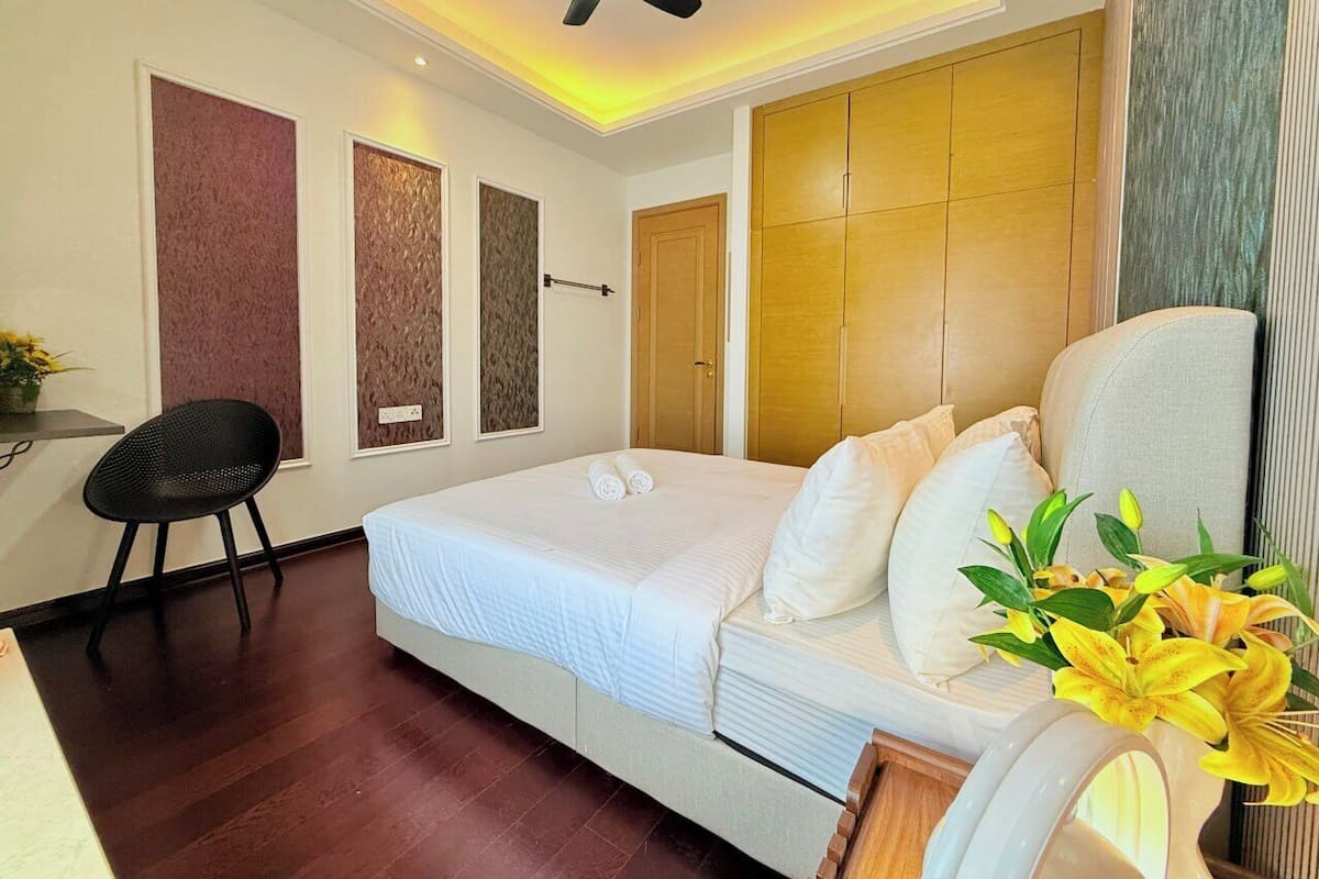 Una habitació d'hotel moderna amb un llit, un escriptori i una cadira.