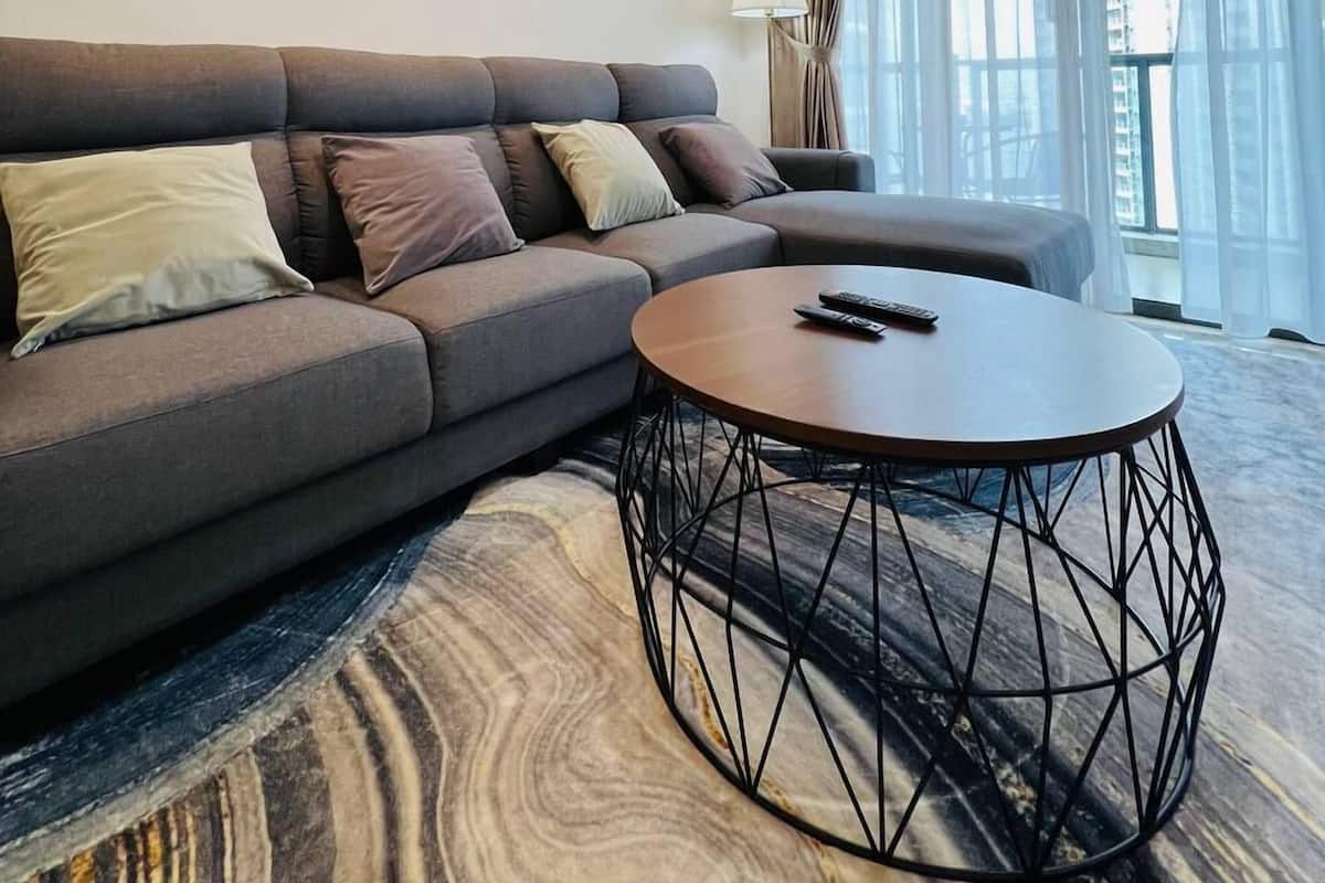 Un saló modern amb un sofà gris, una taula de centre rodona i tres quadres florals enmarcades a la paret.
