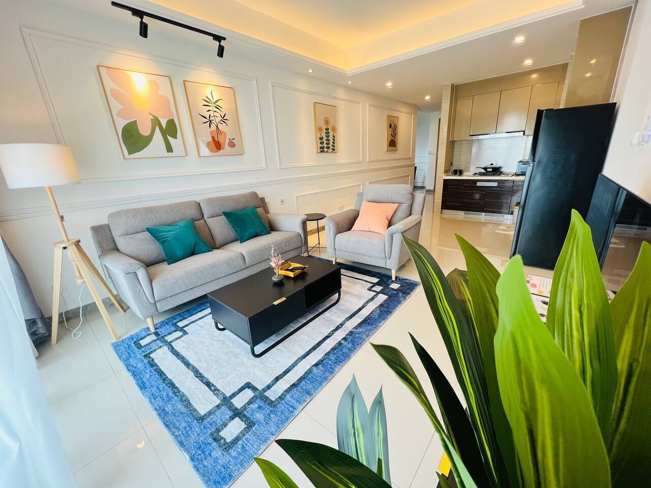 A modern living room with a sofa, armchairs, a coffee table, and a rug.