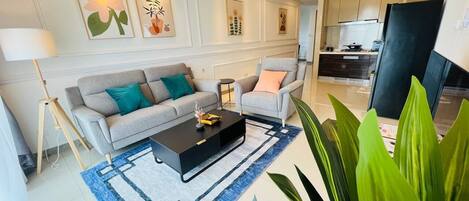 A modern living room with a sofa, armchairs, a coffee table, and a rug.
