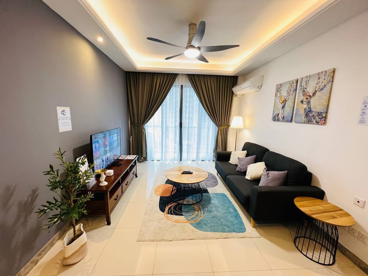 A modern living room with a sofa, coffee table, TV, and decorative items.