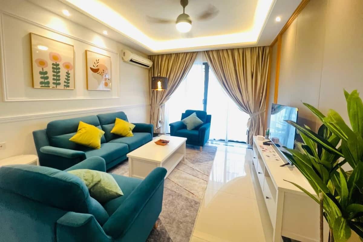 Un saló modern amb sofàs color turquesa, una taula de centre blanca i un televisor sobre un suport blanc.