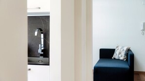 Un baño moderno con un lavamanos de mármol negro y pared blanca.