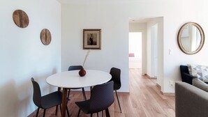 A modern living room with a round dining table, black chairs, a vase, and a framed picture on the wall. - Lovely one-bedroom apartment with balconies overlooking the lake (Dream Lake 3) (Lugano)