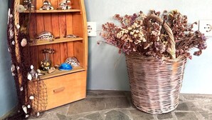 Una estante con forma de barco de madera, adornada con objetos decorativos y una cesta de mimbre con flores secas.