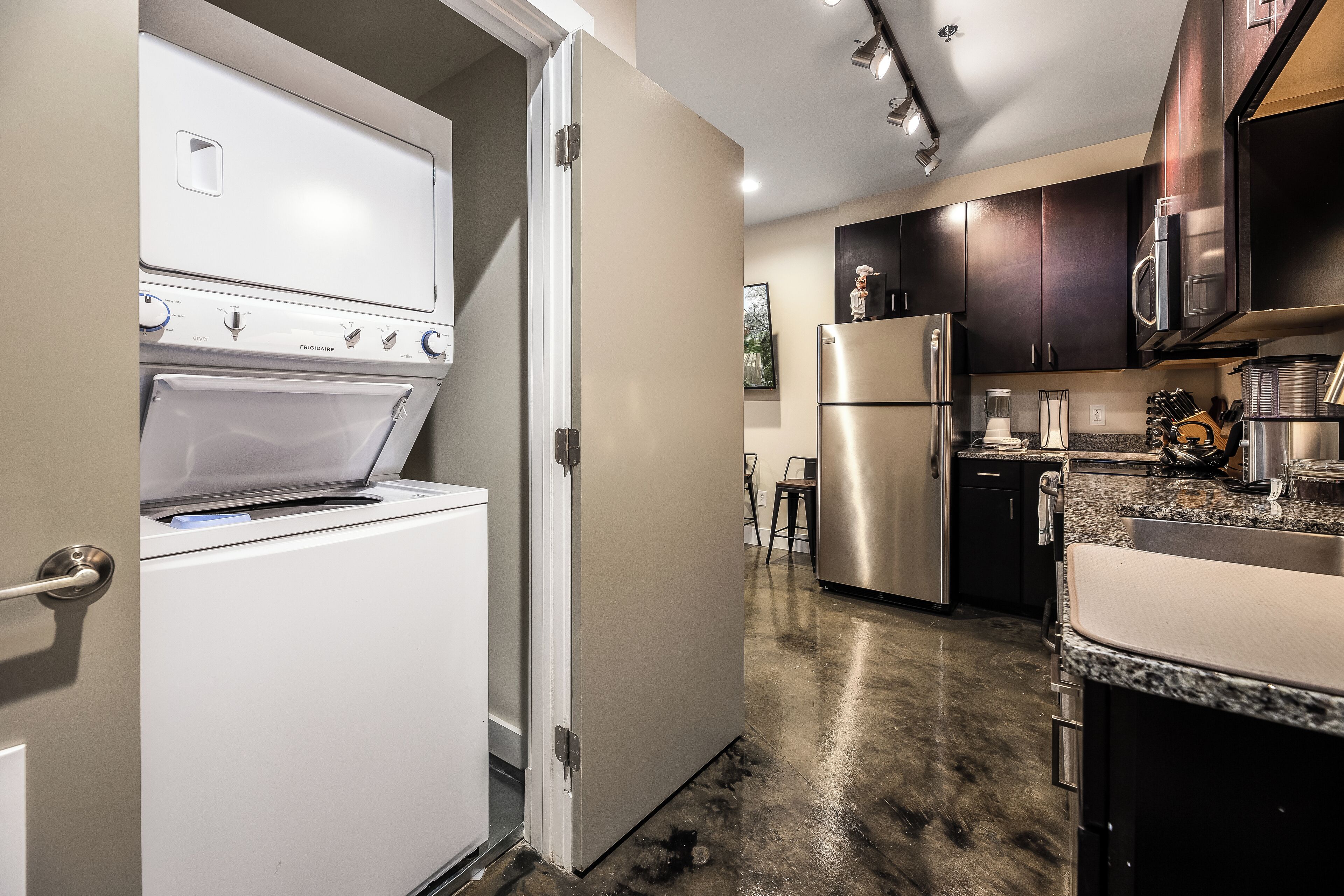 A compact kitchen with a built-in oven, a refrigerator, and a microwave.