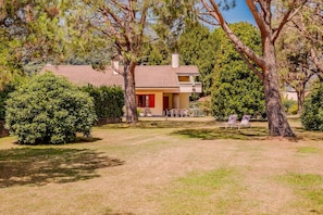 A house with a red door, surrounded by trees and a lawn. - Large lakeside villa (Lesa)