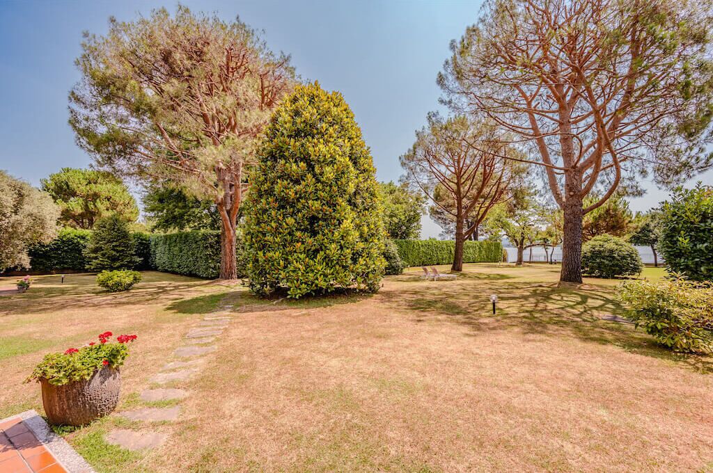 Un jardin bien entretenu, agrémenté de divers arbres et doté d’un chemin pavé.