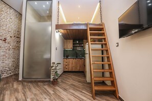 A compact kitchen with wooden cabinets, a built-in refrigerator, and a small countertop.