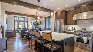 A modern kitchen with a large island, stainless steel appliances, and wooden flooring. - Family Retreat w/ Suncadia Pool Access (Cle Elum)
