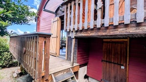 A rustic wooden building with a wooden staircase leading to a porch. - Le Beaulieu Chalet (Beaulieu)