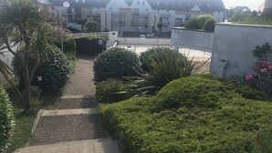 A residential building with a paved pathway leading to a gated entrance.