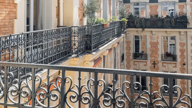A row of terraced houses with balconies, featuring ornate wrought iron railings and a classic European architectural style. - Clichy Couture, by Veeve (Paris)