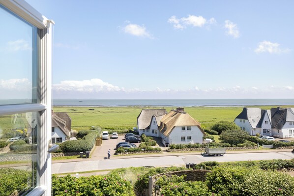 Un village côtier aux maisons blanches, avec un ciel dégagé et une vue sur la mer.