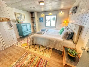 Relax in this inviting bedroom with a large bed, a nightstand, and a potted plant.