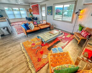 Relax in this stylish living area with a comfortable sofa, colorful throw pillows, and a vibrant rug.