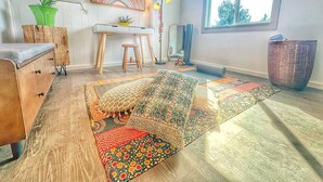 Une pièce comprenant un bureau, une chaise, une grande fenêtre et un tapis à motifs.