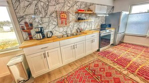 Enjoy cooking in this well-equipped kitchen with an oven, microwave, and stainless steel sink.