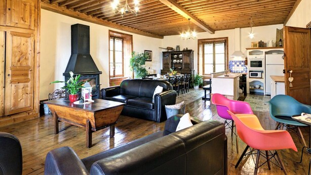 Un interior rústico con vigas de madera, una chimenea, un comedor y una cocina.