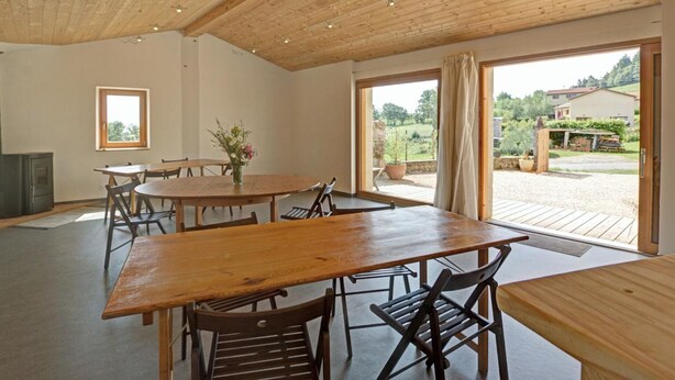 A spacious room with a wooden ceiling, large windows, and a dining area with wooden tables and chairs. - Renovated traditional farmhouse with private courtyard in Verrières-en-Forez (Verrières-en-Forez)