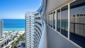 Een modern gebouw met gebogen balkons met uitzicht op een strand en de oceaan.