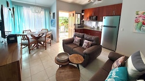 A compact living space with a dining area, kitchen, and seating area. - Happy Oasis Second Floor Condo with Terrace (Playas Del Coco)