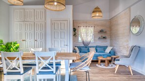 A modern living room with a wooden floor, white furniture, and a blue sofa. - EL SUEÑO : Fantastic house in Pals with private pool and wonderful views of the Medes Islands (Pals)