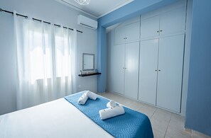 A bedroom with a bed, a wardrobe, a mirror, and a shelf. - La Casa di Volpe (Corfu)