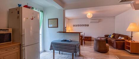 A compact living space with a kitchenette, a dining area, and a seating area.