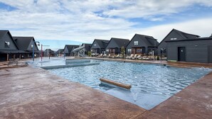 Un espace piscine comprenant des chaises longues et un toboggan aquatique.