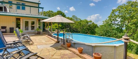 An outdoor swimming pool area with lounge chairs and a covered seating area.