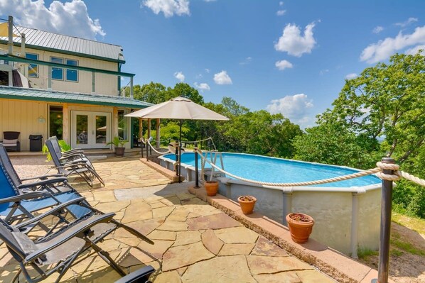 An outdoor swimming pool area with lounge chairs and a covered seating area.
