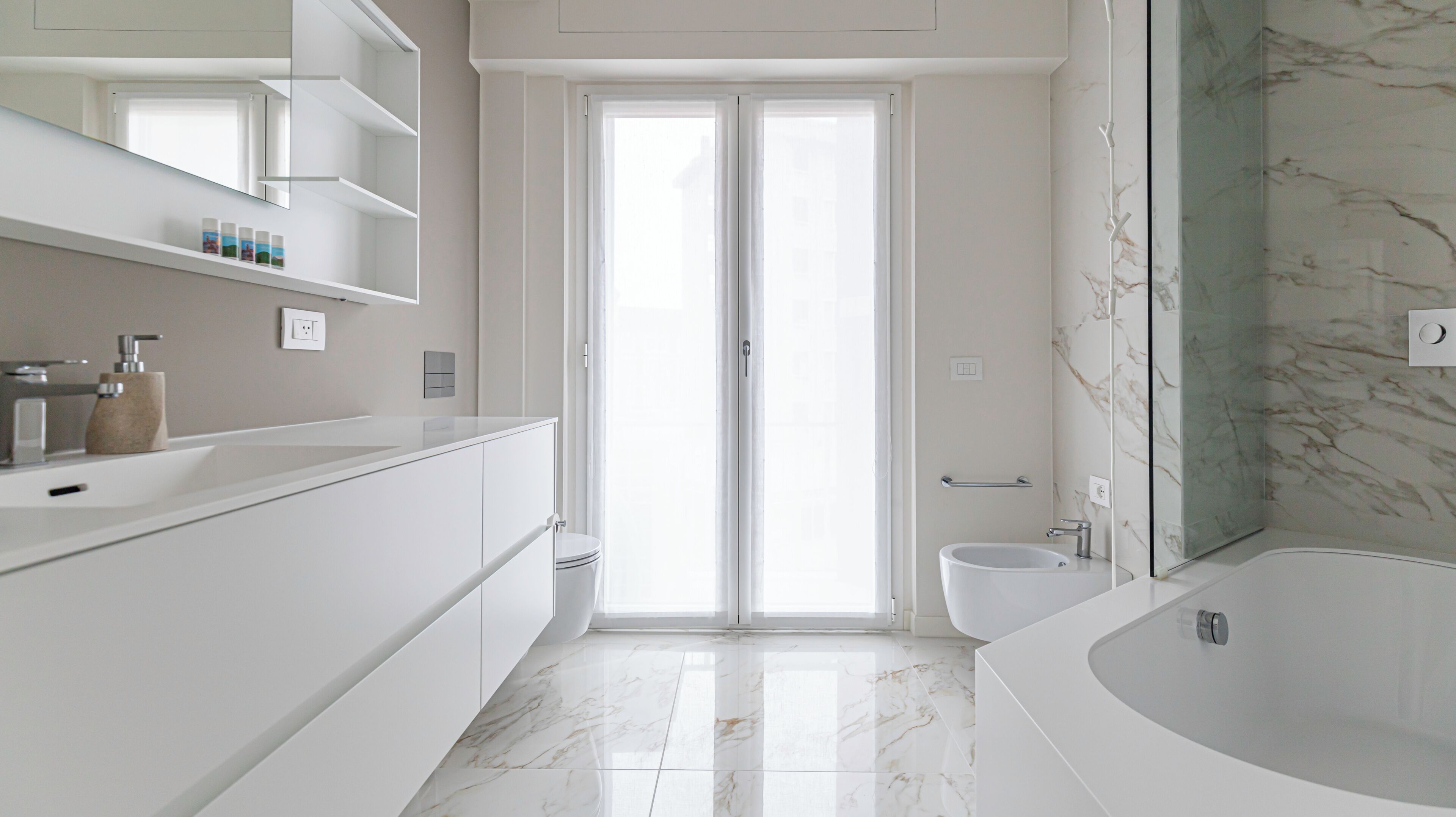 A modern bathroom with a large bathtub, a toilet, and a shower area.
