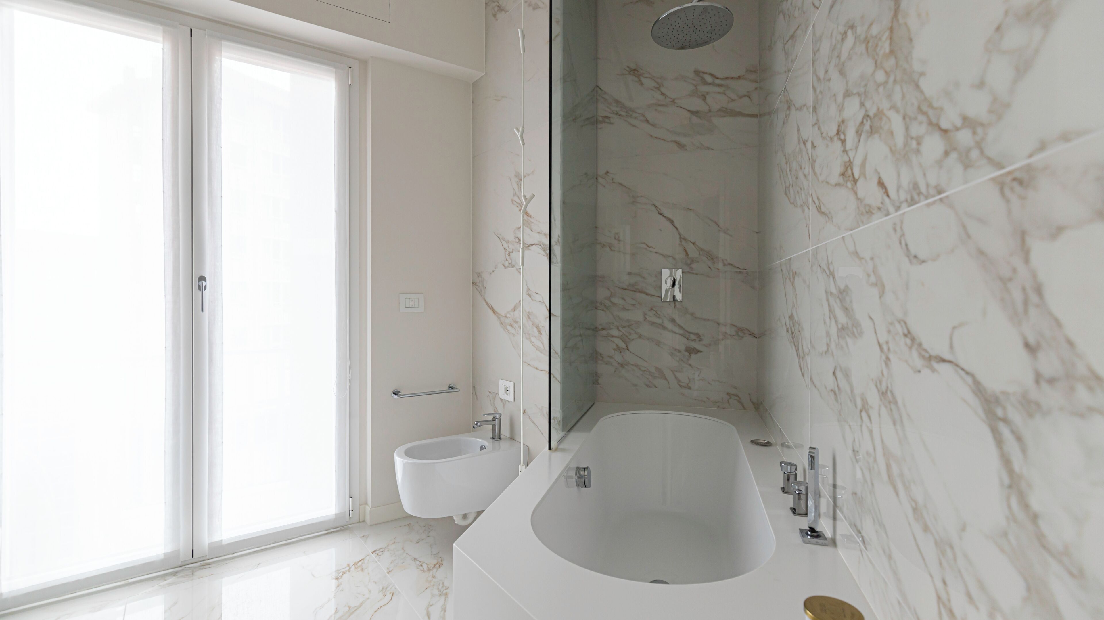 Een moderne badkamer met een ruim bad, een douche en een toilet.