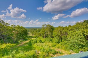 A lush green landscape with a clear sky and scattered clouds.