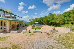 A building with a covered outdoor area, stone planters, and a view of the landscape. - Private Pool & Hot Tub | Fall color view for miles (Eureka Springs)