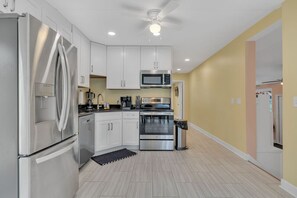 A modern kitchen with white cabinets, stainless steel appliances, and a ceiling fan. - Lakefront, Heated Pool, Sauna, Sleeps 8! (Lebanon)